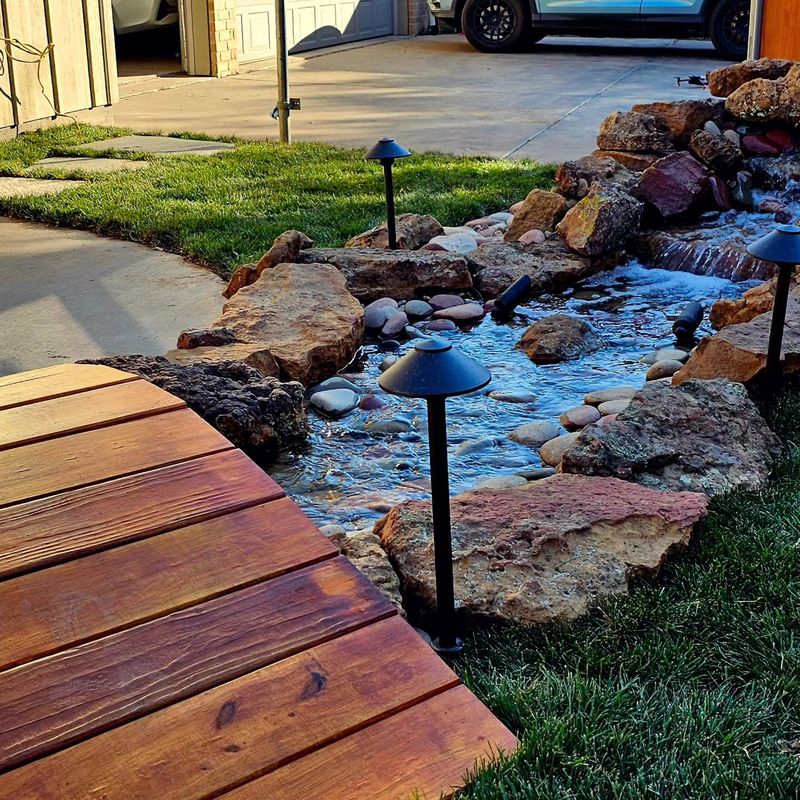 Rock creek bed with lighting beside a deck