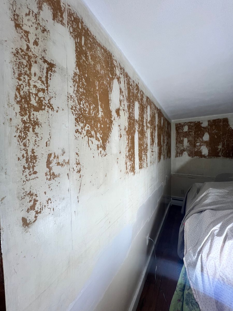 Old wallpaper being stripped from a wall
