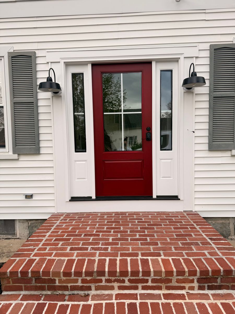 White house with a red front door and brick steps