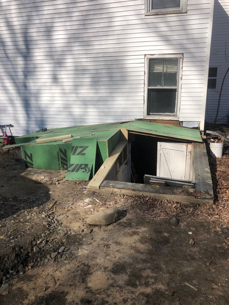 Bulkhead entry sheathed in green ZIP panels with a new door