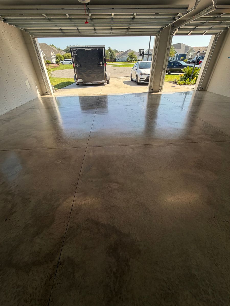 Stained and sealed concrete garage floor reflecting the open garage door