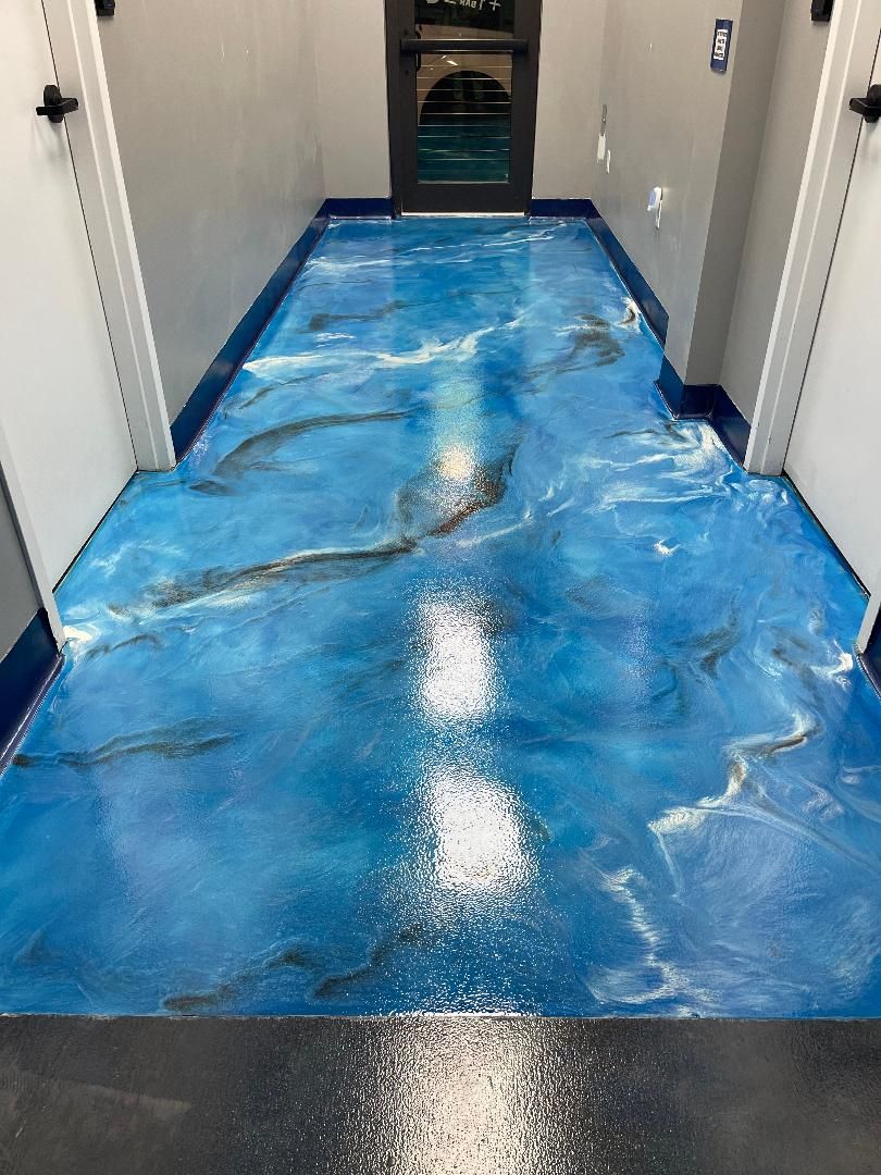 Blue metallic epoxy floor in a narrow commercial hallway