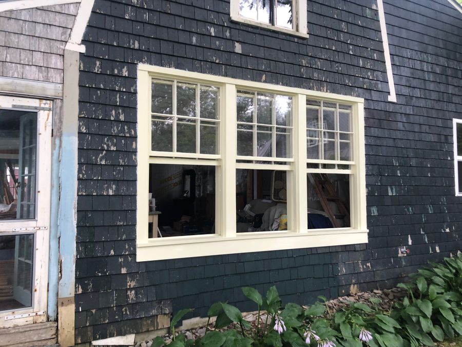 New window trim on a dark shingled wall