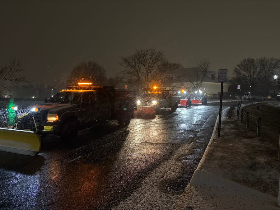 Plow truck clearing a dark driveway