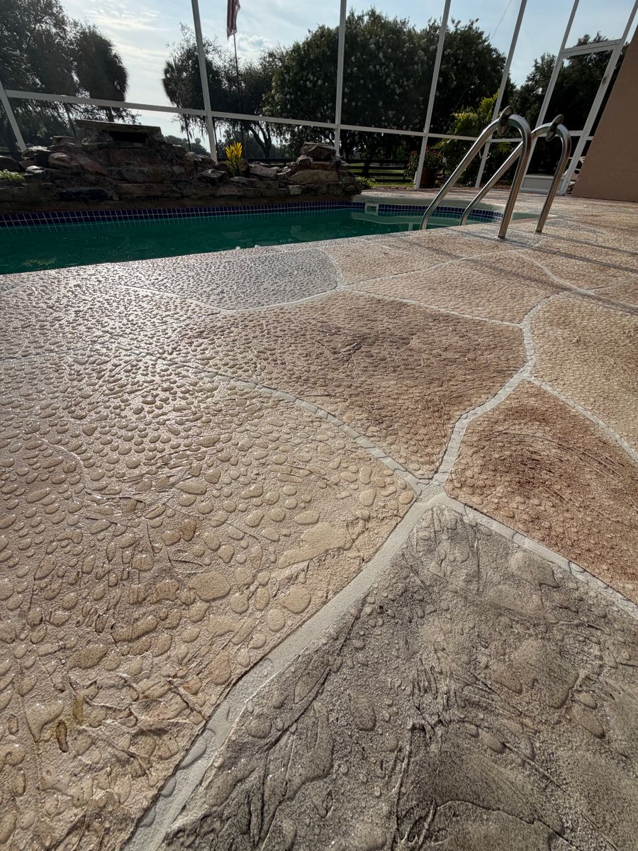 Textured stone overlay pool deck beside the pool steps
