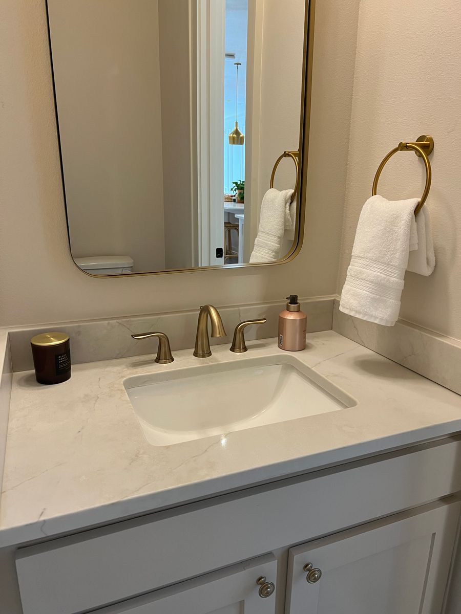Marble vanity with brass fixtures after cleaning