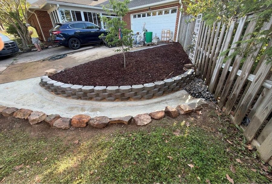 Curved stone-edged planting bed with fresh mulch