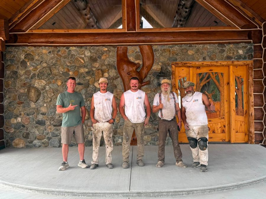 The Chewelah Painting crew outside a log home they finished