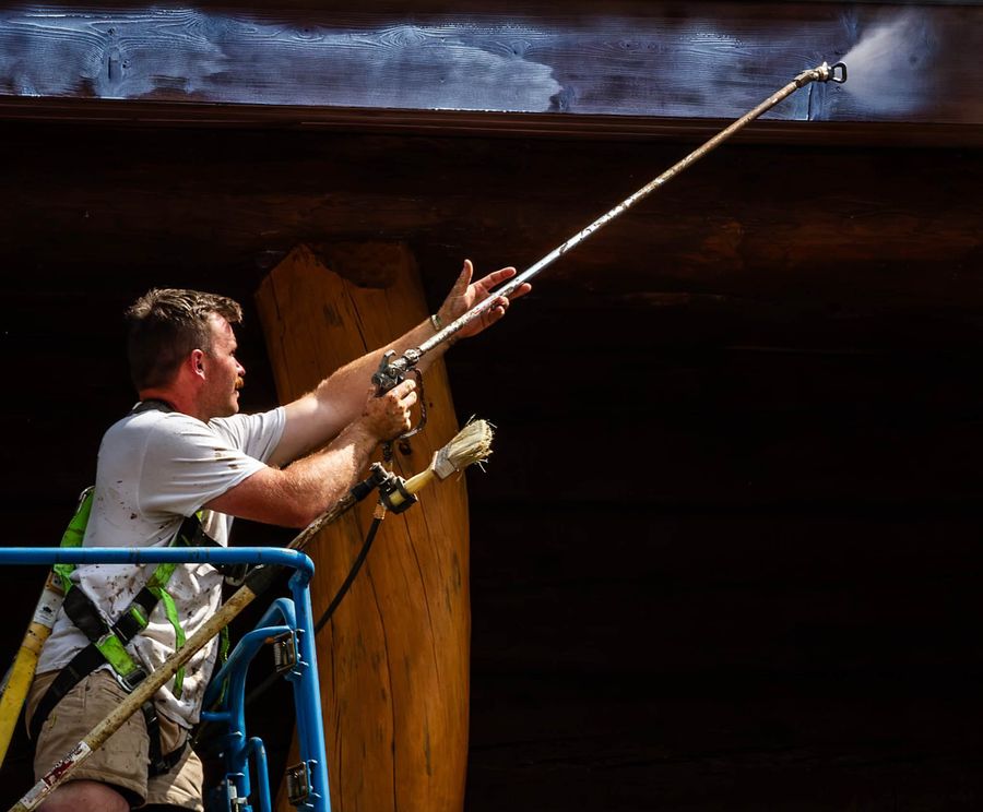 Back-brushing stain on a log wall