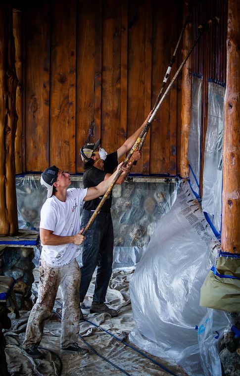 Two of the crew blasting a log wall under containment