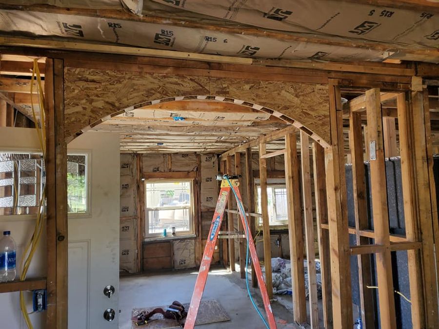 Remodel room framed to the studs with a new arched opening and a ladder