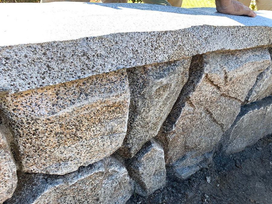 Close view of a stone-look wall and cap