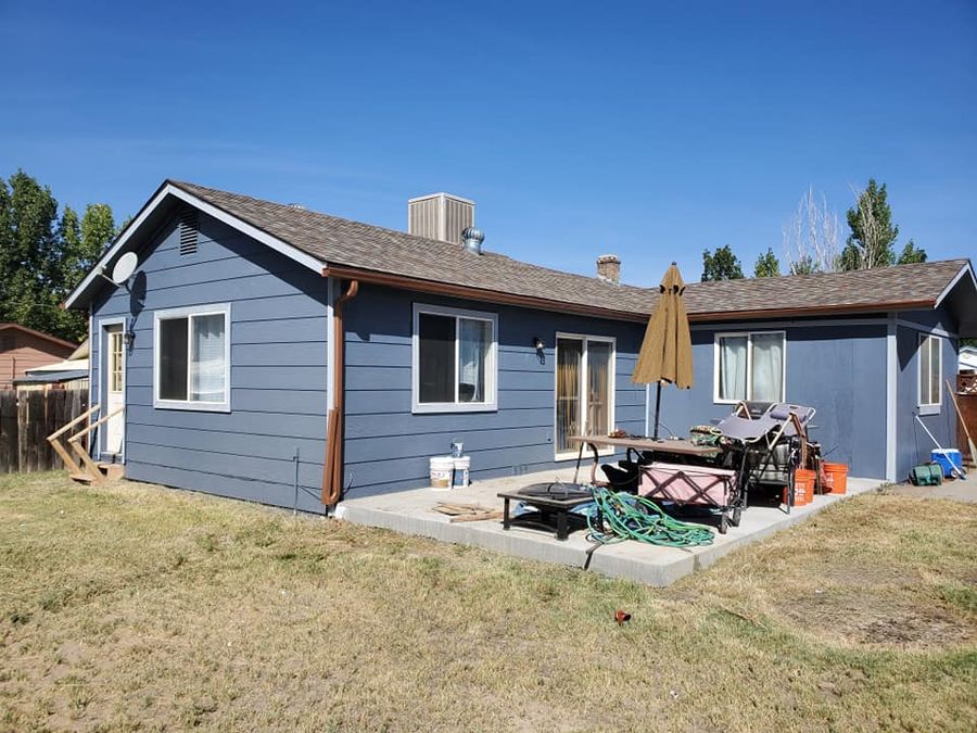 Blue lap-sided house with a back patio