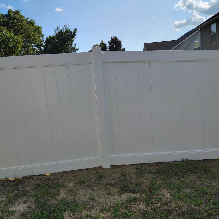 White vinyl privacy fence around a backyard