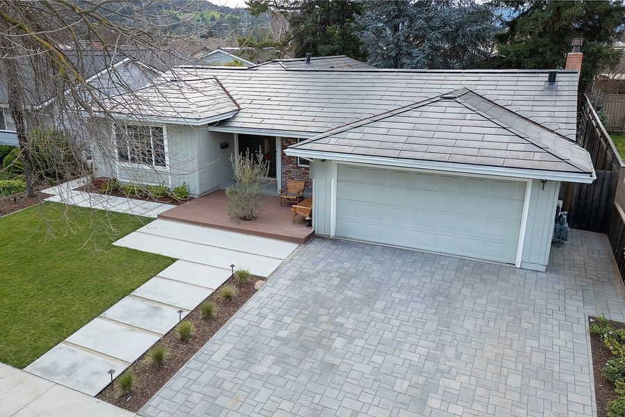 Aerial view of the front of the house showing the concrete paver walkway, grasses in mulch and the paver driveway