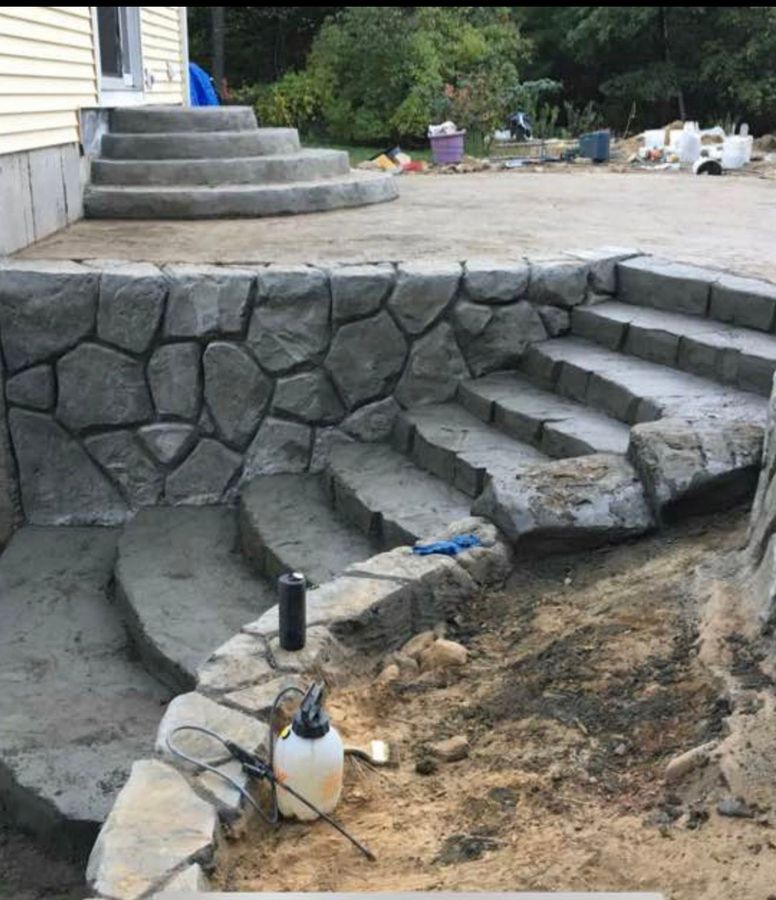 Curved stone-look steps and wall leading up to a patio