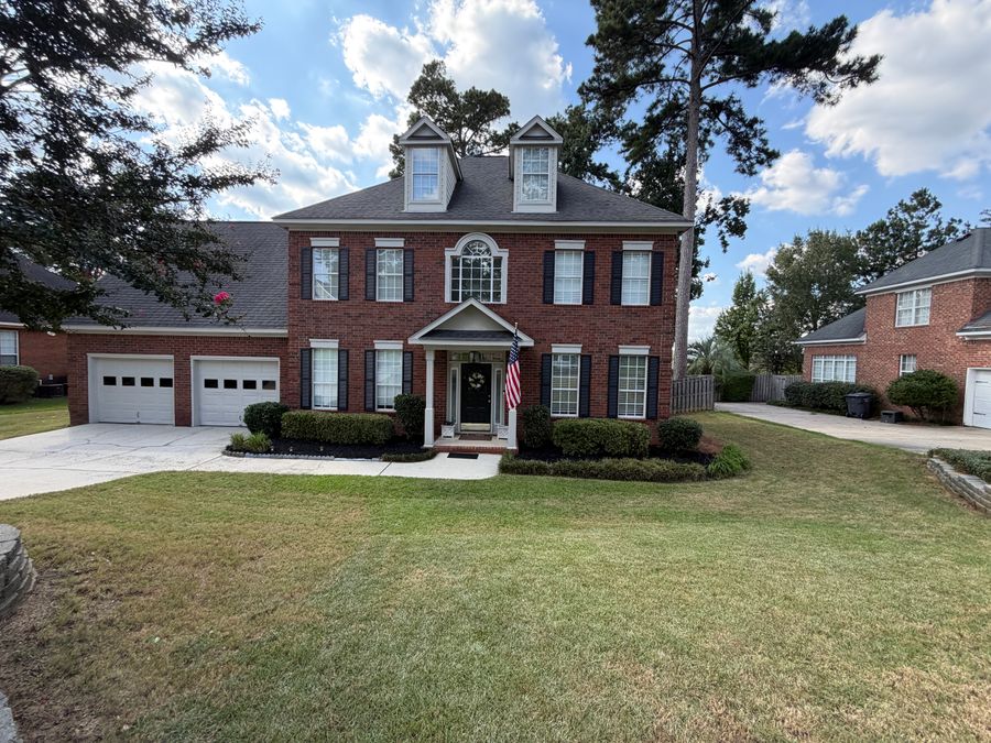 Fresh mulch ring around a tree in front of a brick home, installed by Ascend Outdoors