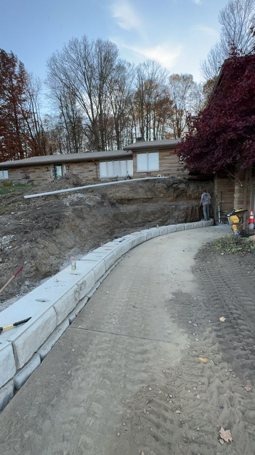 First block courses set along the curved edge of a driveway with the bank cut back behind them