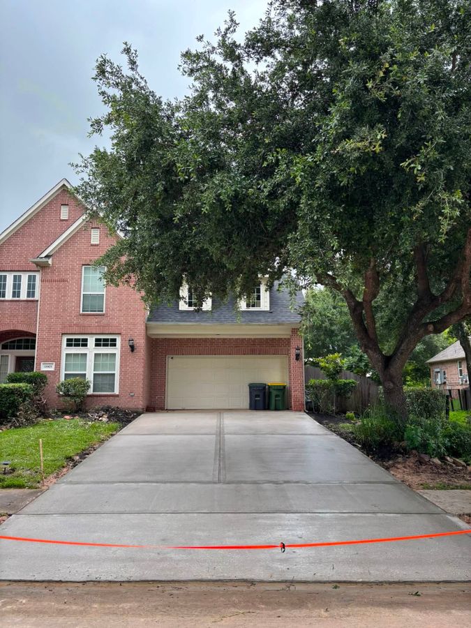 Concrete driveway in front of a two-story brick house