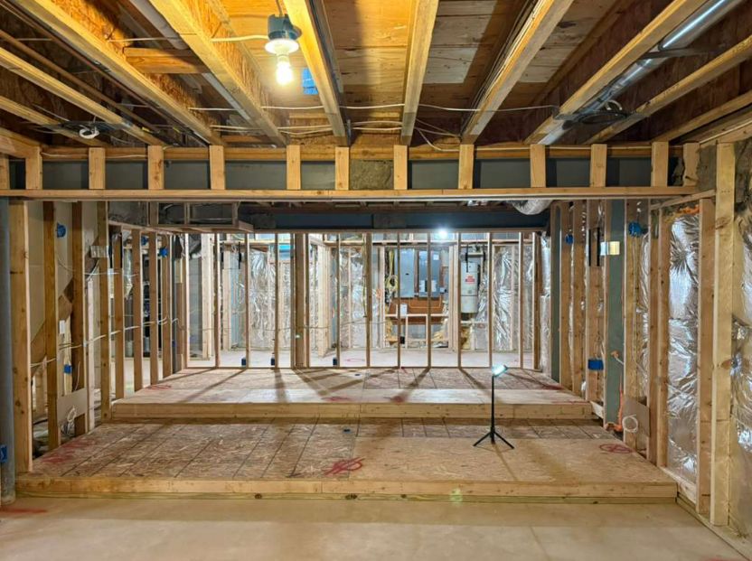 Basement framed for a home theater with a raised platform and open stud walls