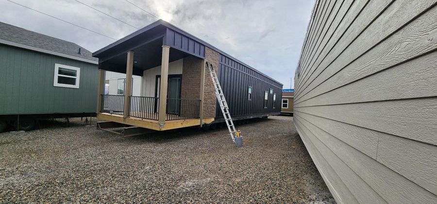 Modular home units with a covered porch and lap siding going on