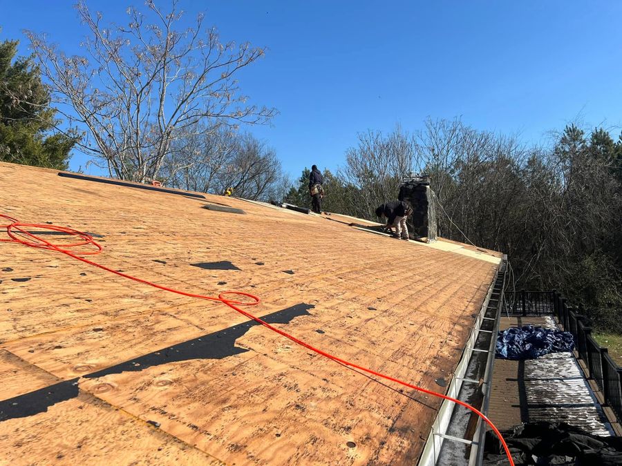 Roofing crew working on an exposed roof deck during a replacement