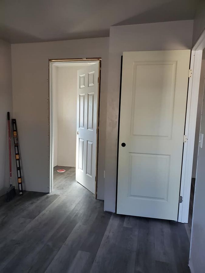 Hallway with white interior doors and grey flooring
