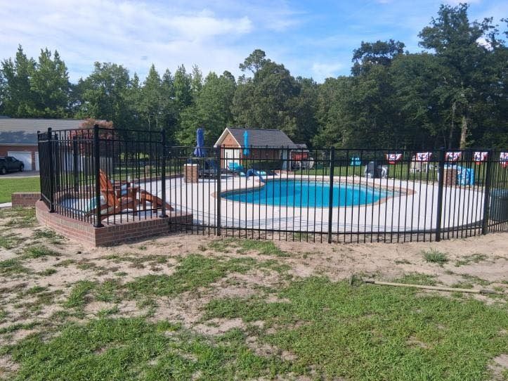 Black aluminum fence around an inground pool
