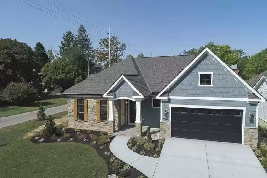 Blue-gray painted home with a stone entry and attached garage