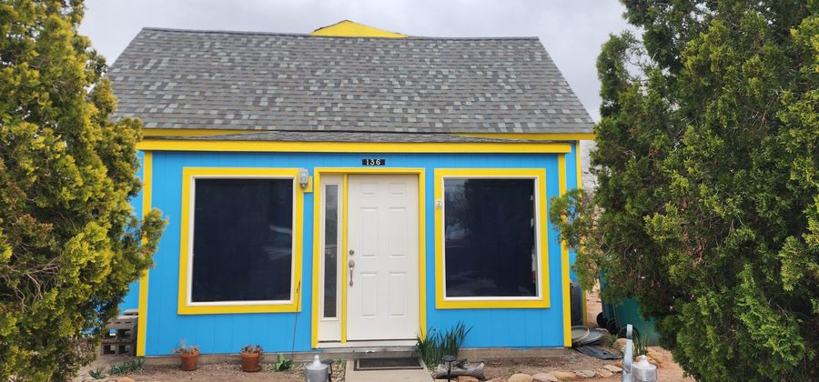 Finished blue and yellow cottage front with fresh exterior paint