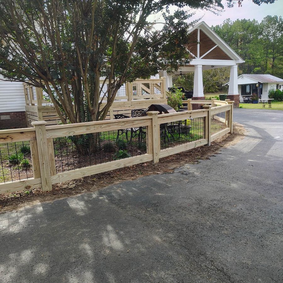 Wood and wire garden fence wrapping a front yard