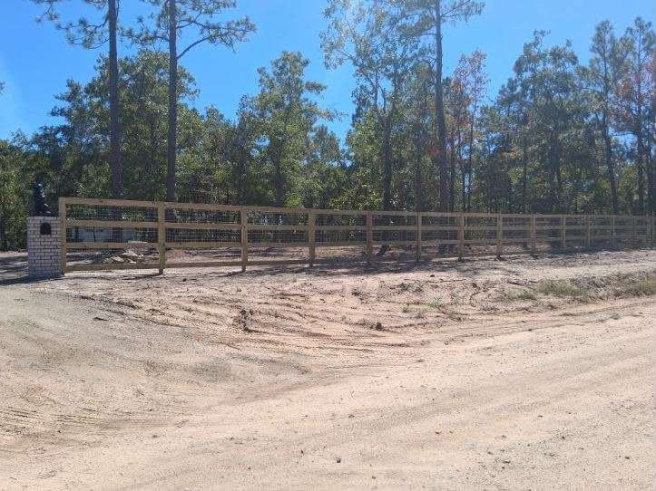 Board farm fence with a brick entry pillar