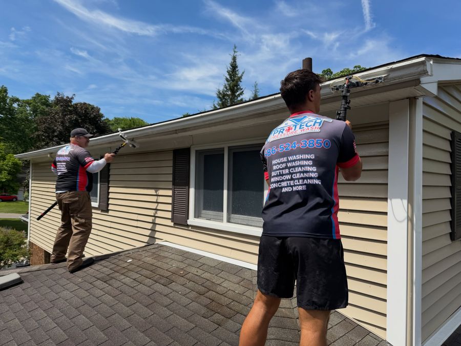 ProTech crew clearing gutters and cleaning soffits on a ranch house
