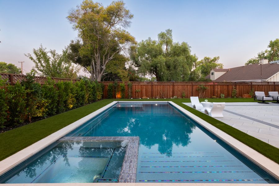 The pool in daylight, artificial turf band along the paved edge