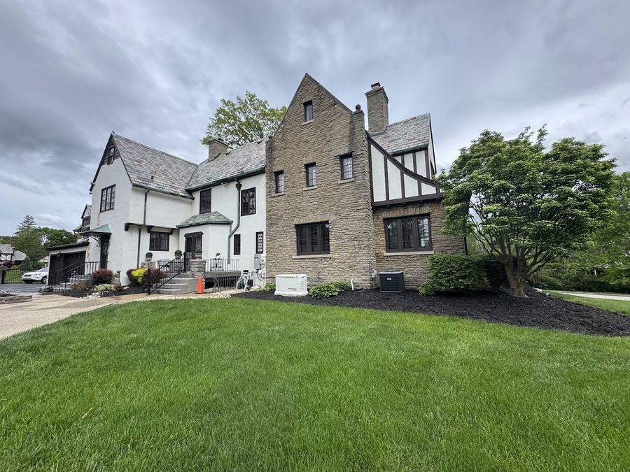 Tudor-style home with a limewashed exterior and stone accents