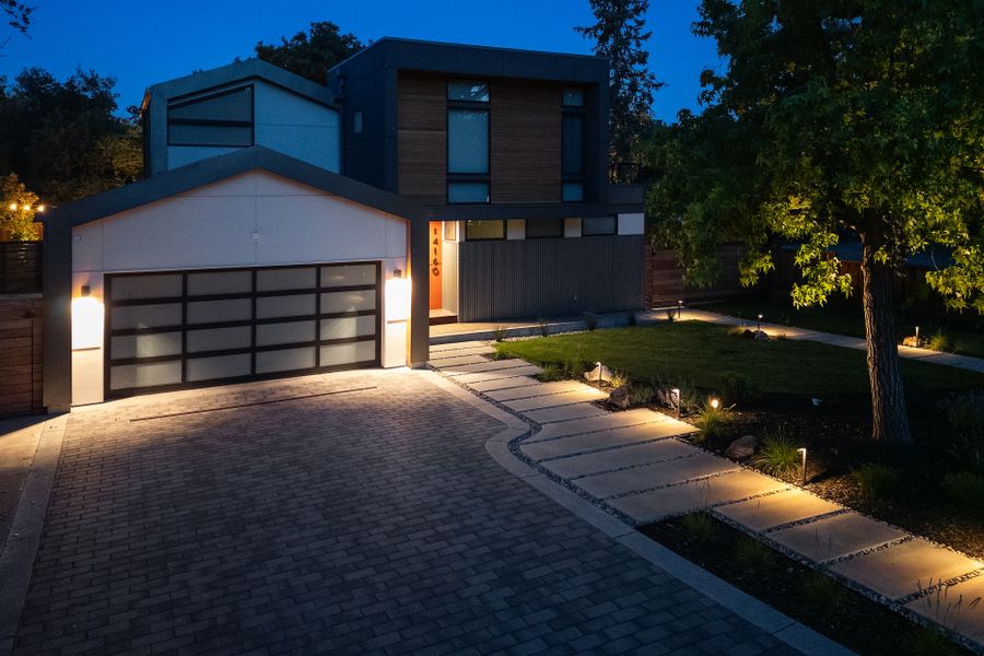 Paver driveway and entry path at dusk, planting beds picked out by path lighting