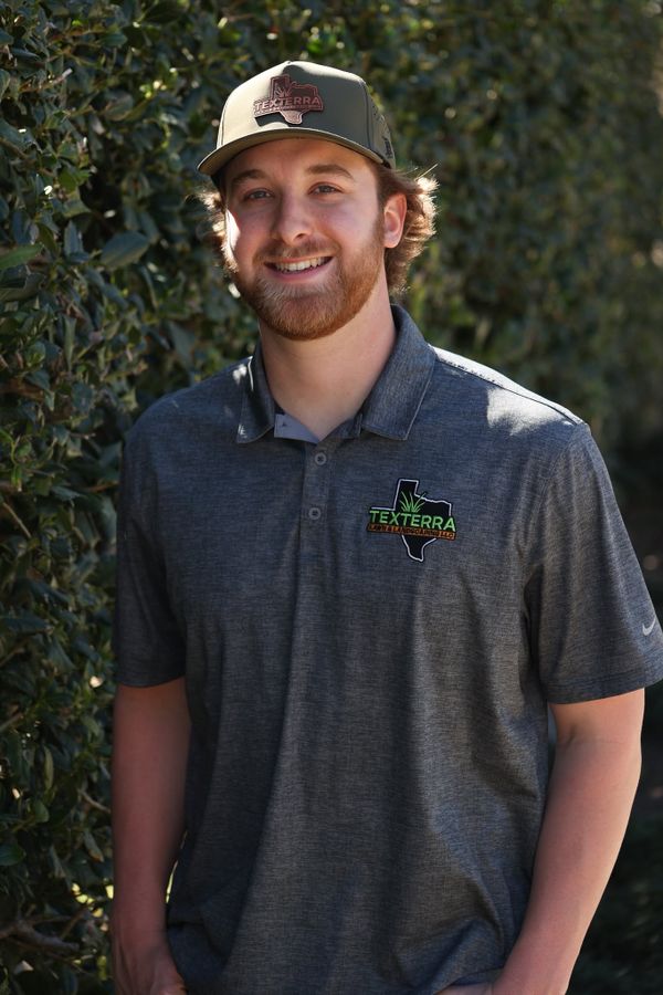 Dalton Snyder, founder of Texterra Lawn & Landscaping, in a Texterra polo and cap