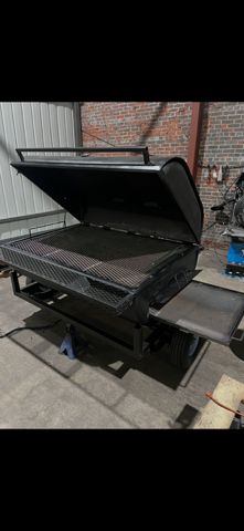 Custom pig cooker with the lid open in the shop