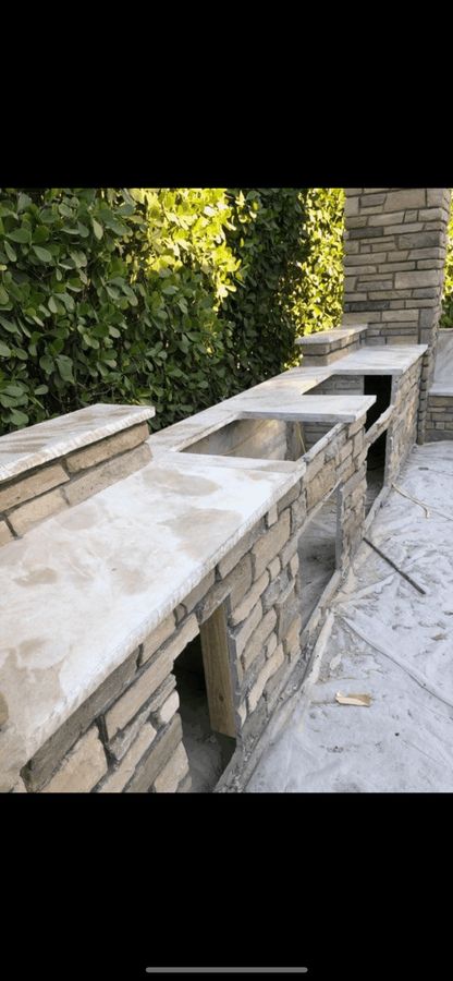 Outdoor kitchen counter with a stone-look base and grill cutout