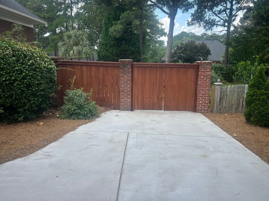 Wood fence and gate stained a cedar red