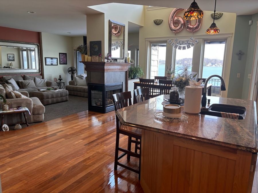 Open lake-house kitchen and living room with wood floors and clean counters