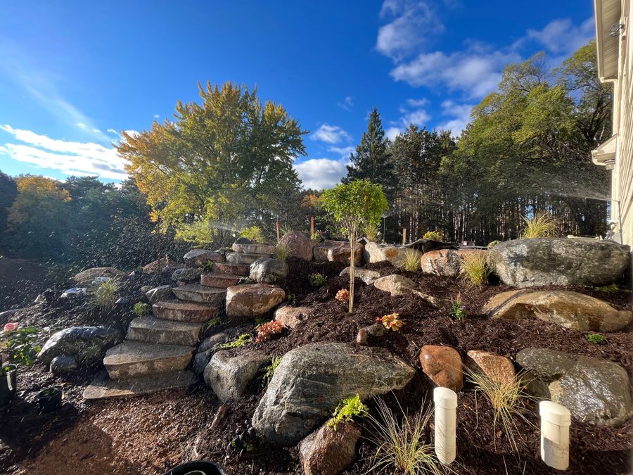 Boulder steps and plantings on a hillside in fall