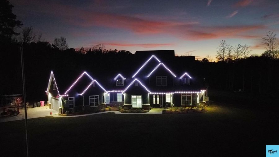 Purple roofline lighting under a sunset sky