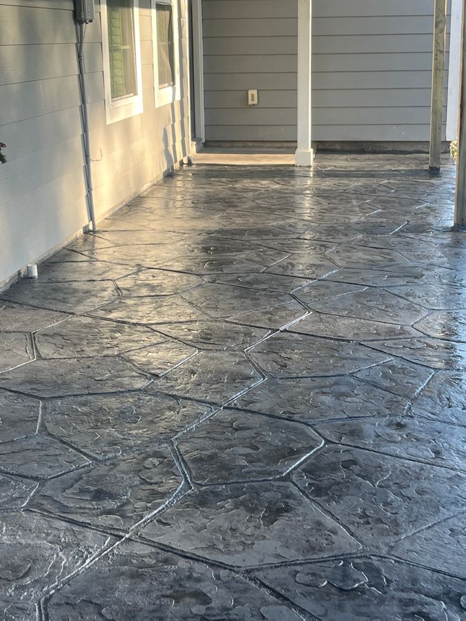 Gray flagstone pattern stamped concrete along a covered porch