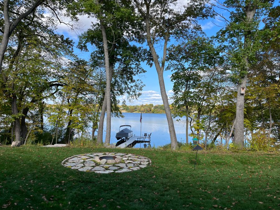Flagstone fire pit circle on a lakeside lawn