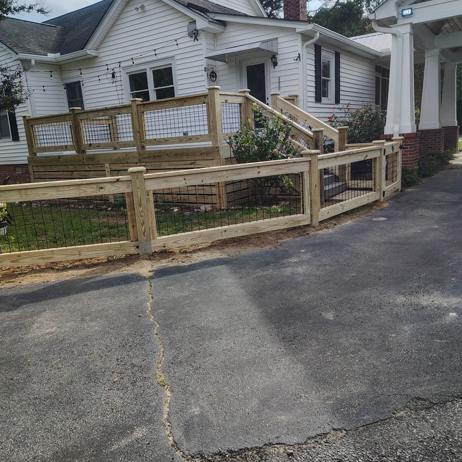 Wood and wire garden fence wrapping a front yard