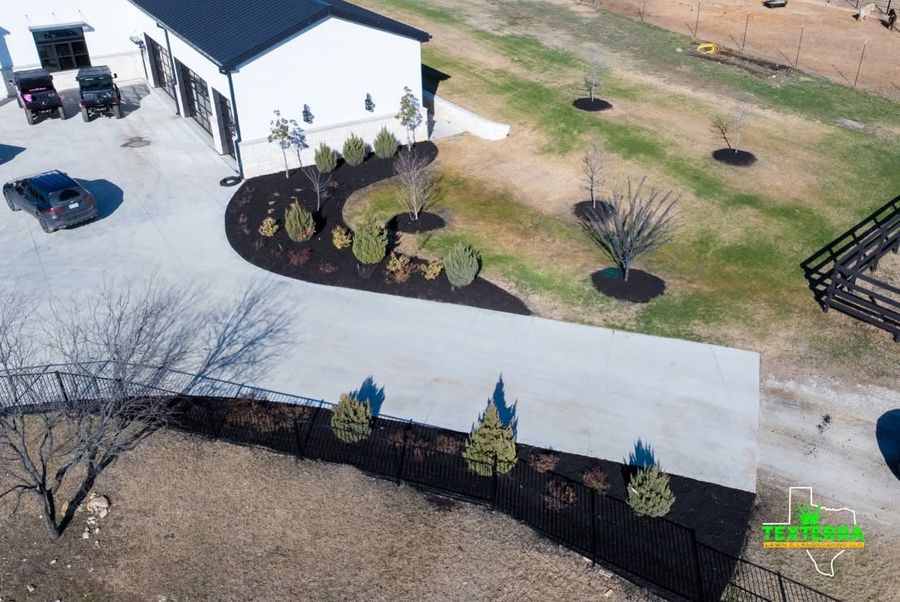 Aerial view of a finished driveway with new landscape beds and plantings