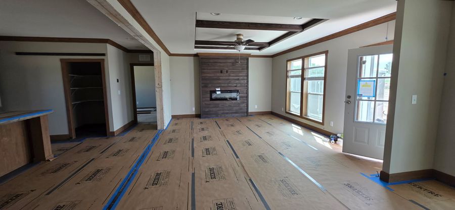 Finished great room with a stone fireplace wall and smooth painted drywall