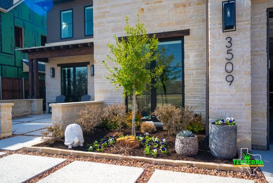 Modern home entry with stone planters and new plantings
