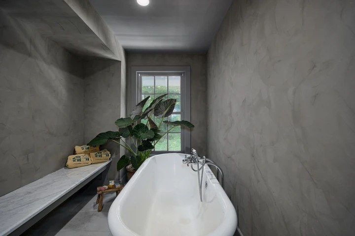 Gray Roman clay walls around a freestanding tub